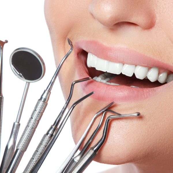 Female smile and detnal tools on white background